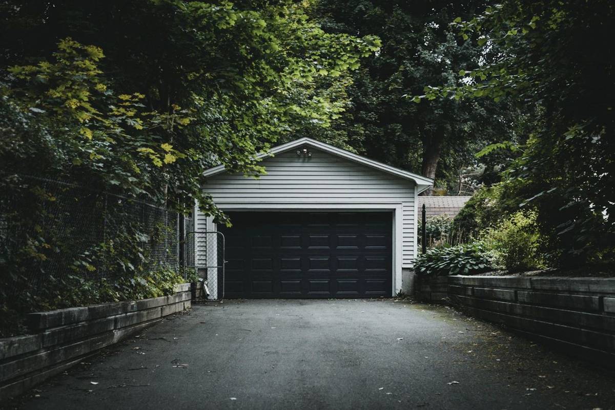 A home garage with a sectional door at the end of a driveway
